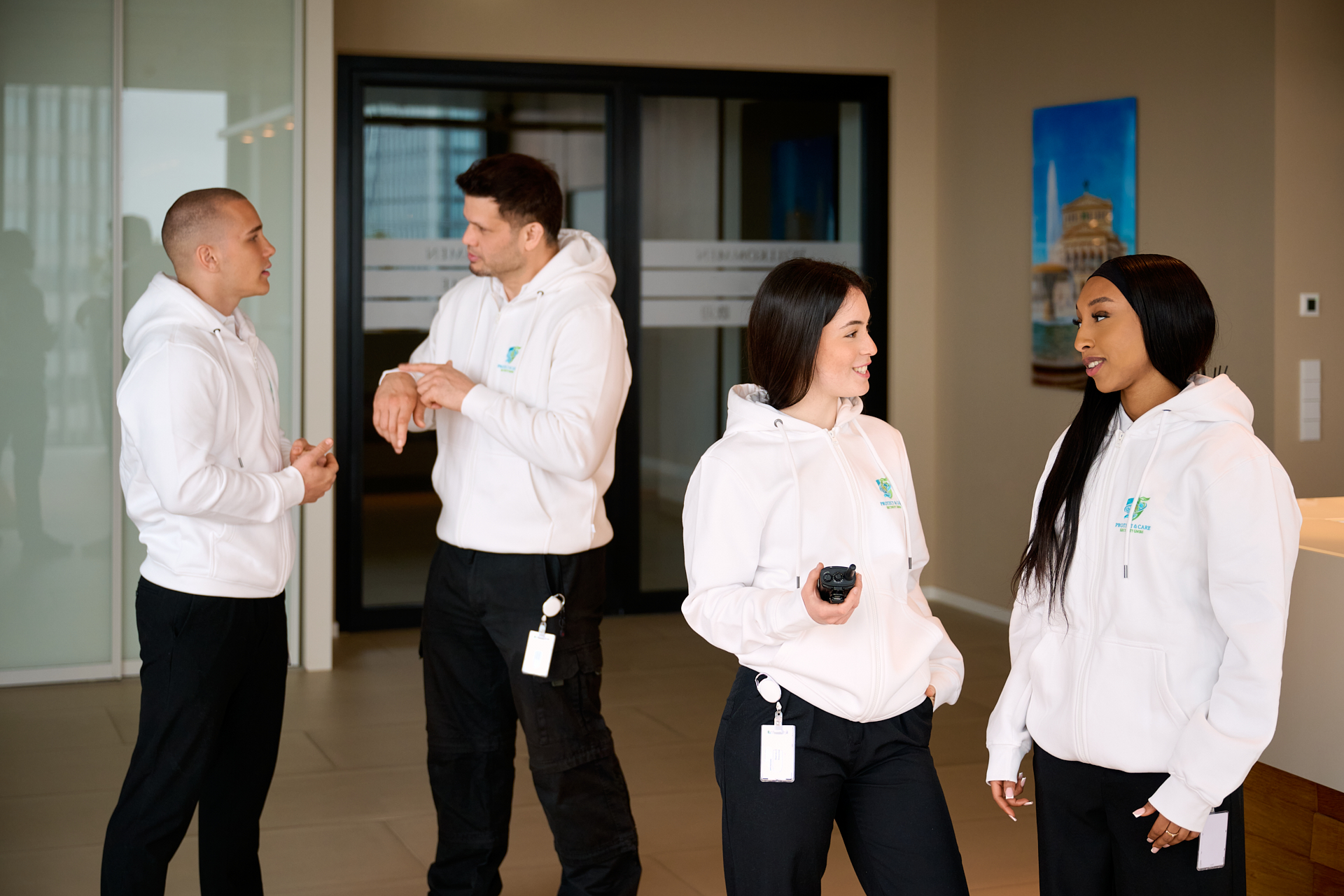 Vier Personen in weißen Hoodies unterhalten sich.