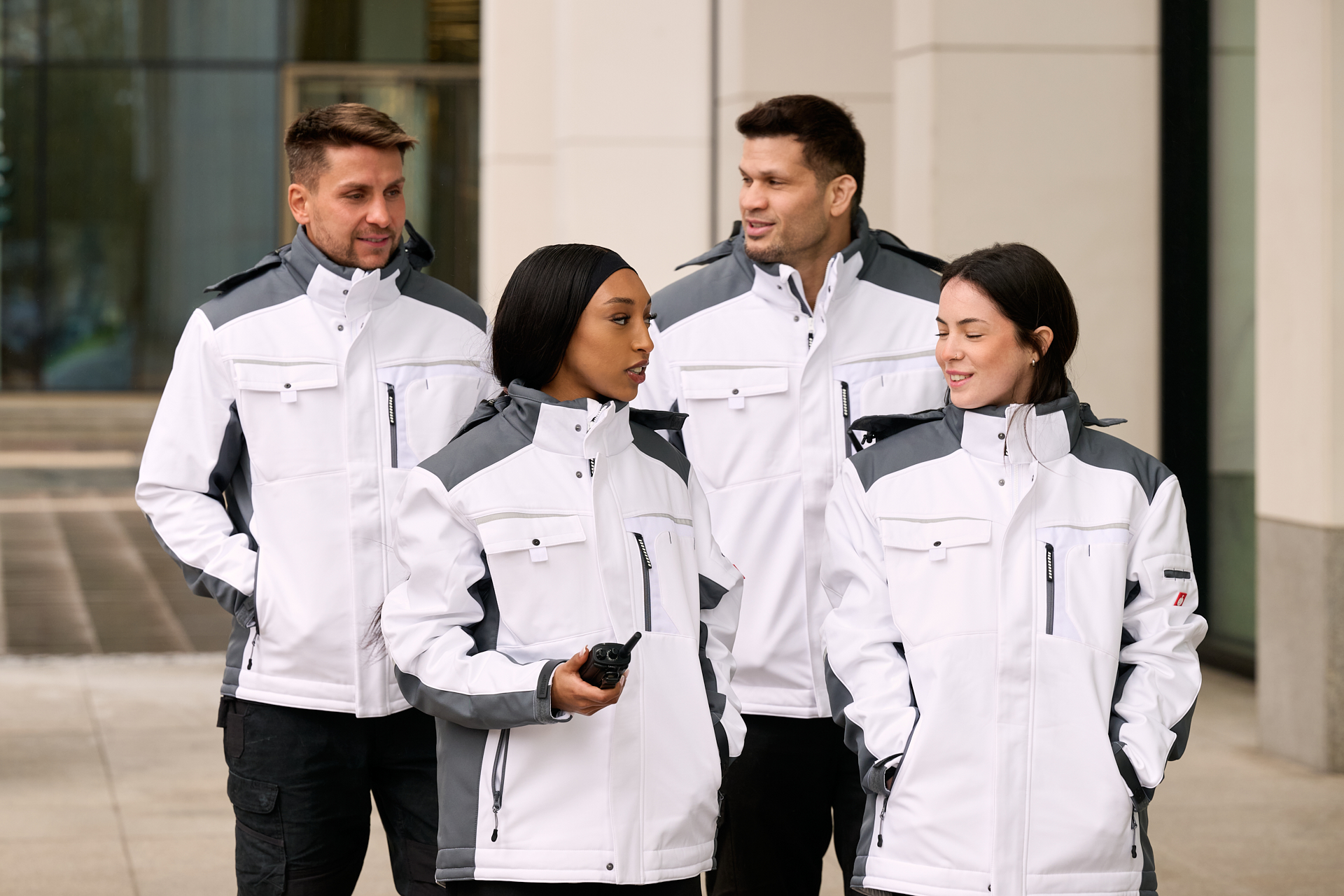 Vier Personen in weißen Jacken stehen zusammen.